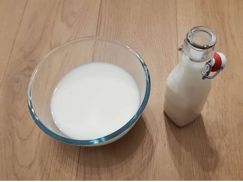 Filtraggio latte d'avena con il colino e il panno di cotone